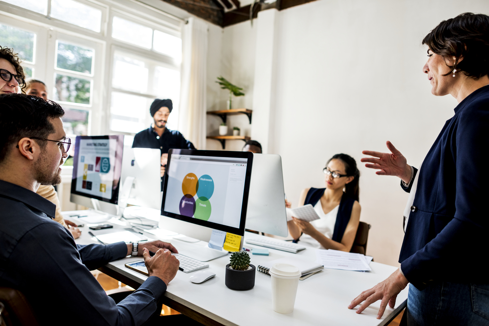 Homepage services thumbnail image for treasury software service section, diverse people people working together around an office table